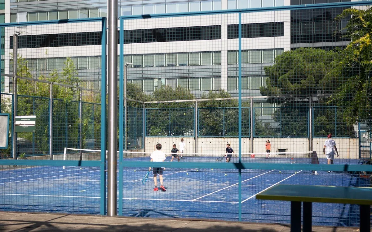 Courts bleus du jardin Atlantique, avec joueurs et bâtiments environnants