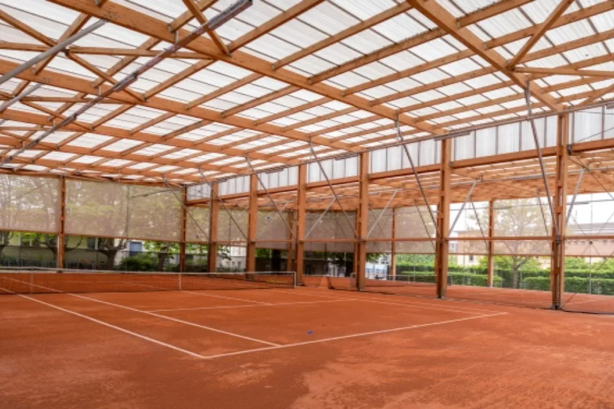 Courts de terre battue du tennis Edouard Pailleron sous leur charpente en bois